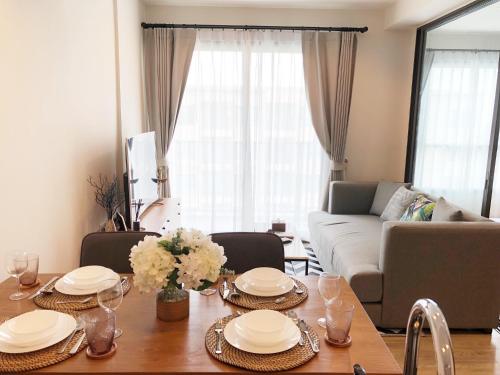 a living room with a table and a couch at Rain Cha-am Huahin By Sake in Cha Am