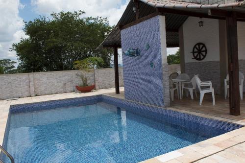 una piscina con mesa y sillas junto a una casa en Maison Delfino Flat, en Gravatá