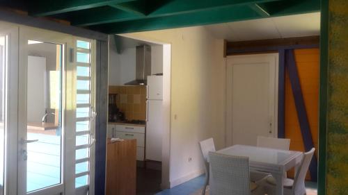 a kitchen with a table and chairs in a room at Habitation Pineau in Deshaies