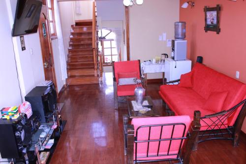 a living room with a red couch and red chairs at The House in Tacna