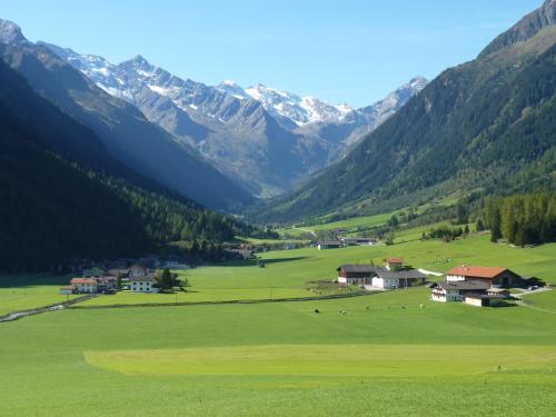 a large green field with mountains in the background at Conny's Ferienwohnungen in Gschnitz