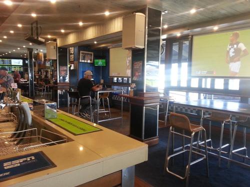a man sitting at a bar in a restaurant at Grand Tasman Hotel in Port Lincoln
