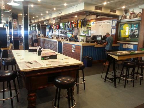 a bar in a restaurant with people standing at a counter at Grand Tasman Hotel in Port Lincoln