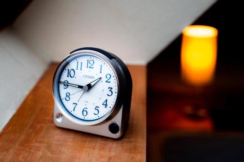a clock sitting on top of a wooden table at Rusutsu Lodges Pension Lilla Huset in Rusutsu