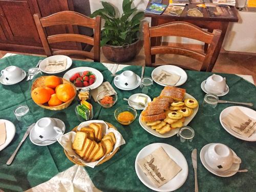 een tafel met borden en kommen brood en fruit bij Agriturismo Furfullanu in Nurallào