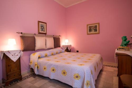 una camera da letto con un grande letto e pareti rosa di Abruzzo Segreto a Navelli