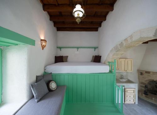 a bedroom with a bed in a green room at Hartso - Traditional loft, renovated former forge in Gennadi in Gennadi