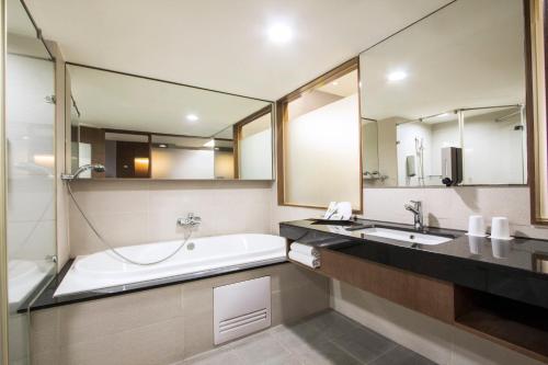 y baño con bañera, lavabo y espejo. en VIP Hotel, en Taipéi