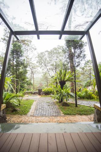 a view of the garden from the inside of a glass house at Melia Ba Vi Mountain Retreat in Hanoi