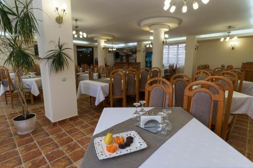 a restaurant with tables and chairs and a plate of fruit at Pension Vanatorul in Vatra Dornei