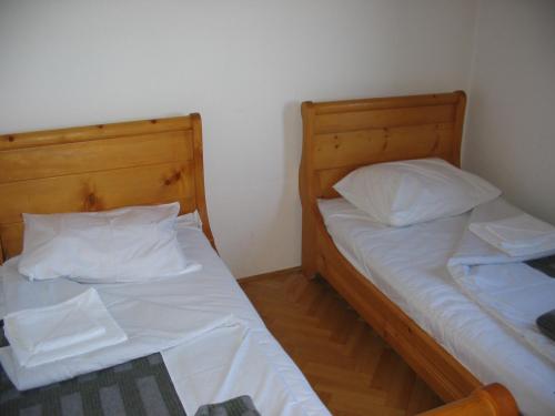 two beds in a room with white sheets and pillows at Villa Kostic Kopaonik in Kopaonik