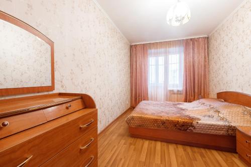 トムスクにある2к квартира в Ленинском районеのベッドルーム1室(ベッド1台、ドレッサー、鏡付)
