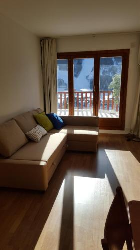 a living room with a couch and a large window at Tarter Confort in El Tarter
