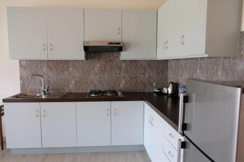 a white kitchen with white cabinets and a sink at Twenty-Two Weligambay in Weligama
