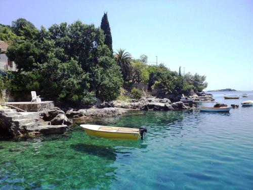 a yellow boat in a body of water at Villa Riva in Molunat