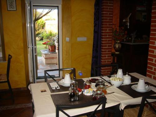 a table with two chairs and a table with food on it at Hotel Rural La Rosa de los Tiempos in Carneros