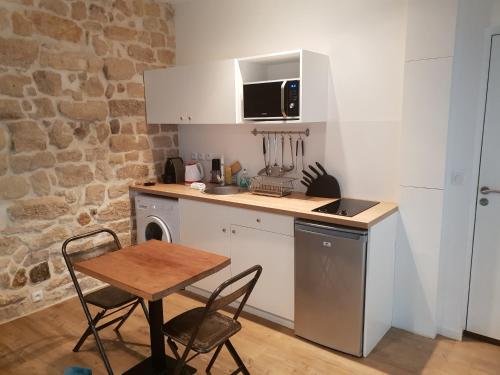 eine kleine Küche mit einem Tisch, einem Tisch und Stühlen in der Unterkunft Transparent Marais in Paris