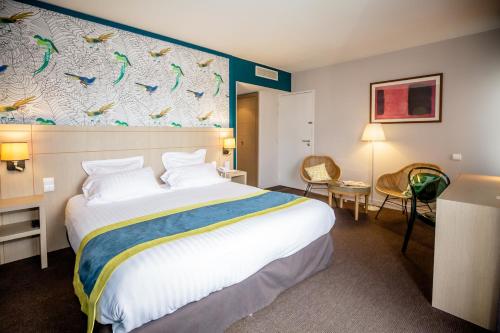 a hotel room with a bed and a wall with birds at Best Western Plus Hôtel Vannes Centre Ville in Vannes