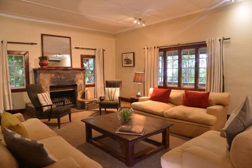 a living room with a couch and a fireplace at Tala Collection Game Reserve in Silverton