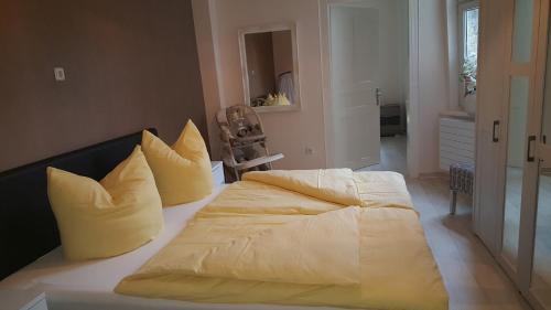 a bedroom with a large bed with yellow pillows at Vogelnest in Mühlhausen