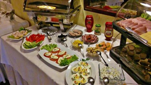 シフィノウイシチェにあるKamienica pod Kasztanami Świnoujście (Usedom Insel)のさまざまな種類の食べ物が並んだテーブル