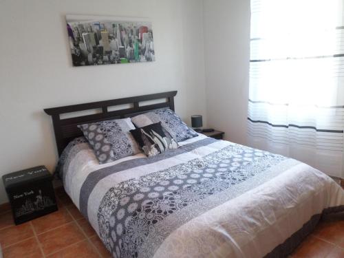 Un pat sau paturi într-o cameră la les romarins appartement climatisé
