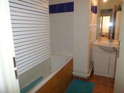 La salle de bains est pourvue d'une baignoire et d'un lavabo. dans l'établissement les romarins appartement climatisé, à La Seyne-sur-Mer