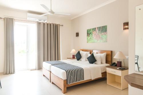 a bedroom with a bed and a large window at Twenty-Two Weligambay in Weligama