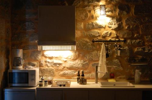 a kitchen with a counter with a microwave and a sink at Philothea Guest House Mani Greece in Mitziólena