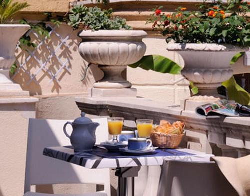 einen Tisch mit zwei Gläsern Orangensaft und einem Tee-Set darauf in der Unterkunft Villa Saint Hubert in Nizza