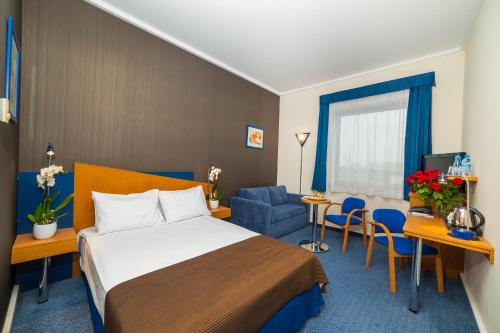 a hotel room with a bed and a blue chair at Express Kraków Hotel in Kraków