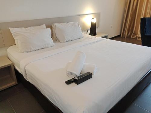 a hotel room with a large white bed with a camera on it at O'Boutique Suites Hotel @ Bandar Utama in Petaling Jaya
