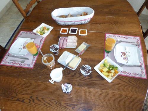 BnB chez Fanfan في مورغيس: طاولة عليها أطباق من المواد الغذائية والمشروبات