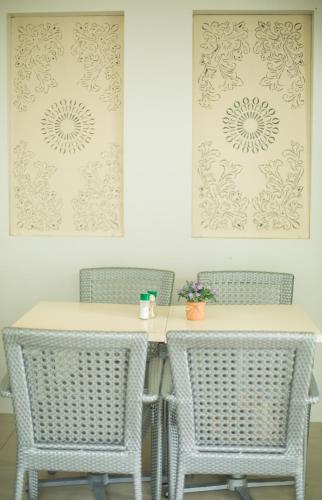 a dining room table with three chairs and a picture at Grand Blue Beach Hotel in Boracay