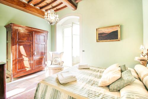 um quarto com uma cama e um sofá num quarto em Apartment Guinigi with Private Courtyard em Lucca