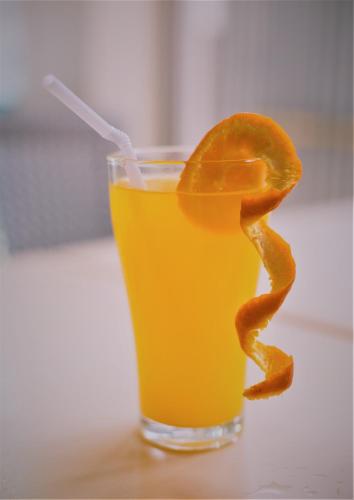 a glass of orange juice with an orange peel in it at Grand Blue Beach Hotel in Boracay