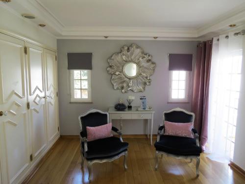 a living room with two chairs and a mirror at Villa Moments - Guest House in Portimão