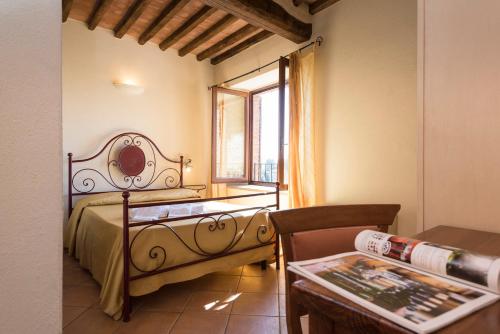 um quarto com uma cama, uma mesa e uma janela em Bed & Breakfast Suvereto em Suvereto