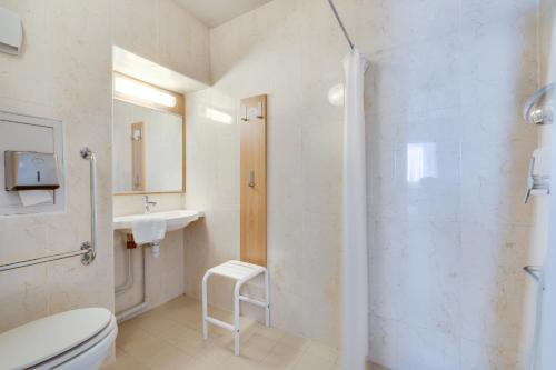 La salle de bains est pourvue d'une douche, de toilettes et d'un lavabo. dans l'établissement B&B HOTEL FREJUS Puget-sur-Argens, à Fréjus