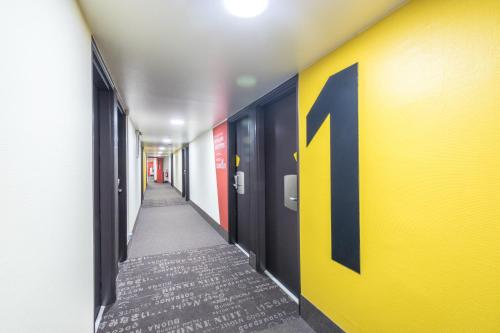 a hallway with a yellow wall with a number on it at B&B HOTEL FREJUS Puget-sur-Argens in Fréjus