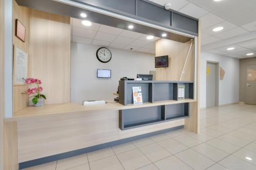 a lobby of a hospital with a clock on the wall at B&B HOTEL FREJUS Puget-sur-Argens in Fréjus