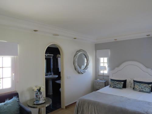 a bedroom with a bed and a sink and a mirror at Villa Moments - Guest House in Portimão