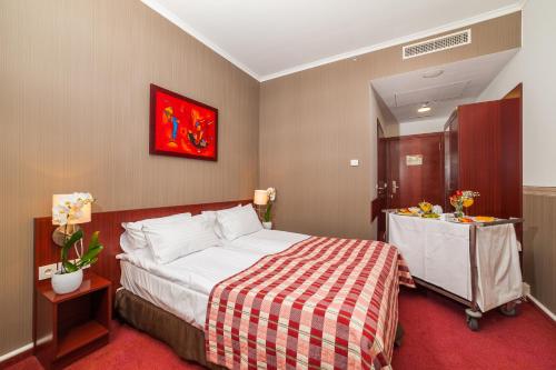 a bedroom with a bed with a red and white blanket at Premier Kraków Hotel in Kraków