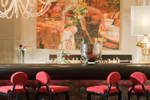 a bar with red chairs and a painting on the wall at Brunelleschi Hotel in Florence