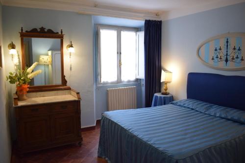 a bedroom with a blue bed and a mirror at Palazzo Tucci Apartments in Lucca