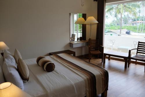 a bedroom with a large bed in a room with a window at Twenty-Two Weligambay in Weligama