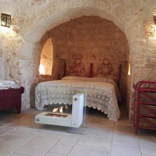a bedroom with a bed with a fireplace in it at Trulli di Ivana in Ostuni