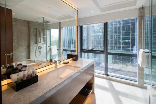 a bathroom with a large sink and a large window at Fraser Suites Shenzhen, Near Huaqiang North Business Zone and next to shopping mall complex, with direct subway access in Shenzhen