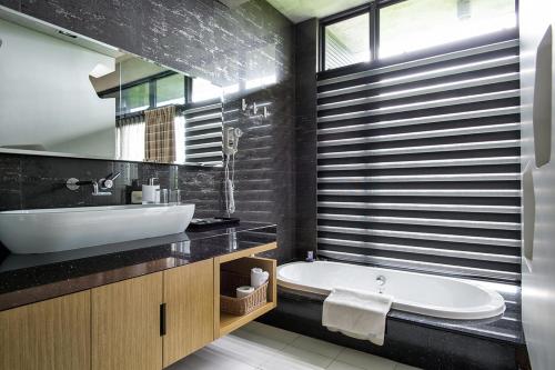 五結鄉的住宿－Hiten Villa，带浴缸、水槽和镜子的浴室