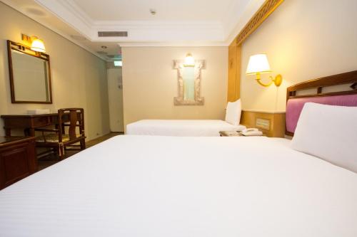 a hotel room with two beds and a desk at SL MOTEL in Zhonghe